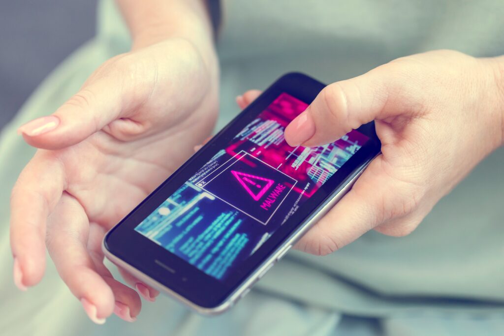 Mobile phone in female hands with screen showing compromised virus infected device, malware